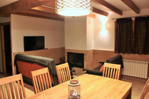 a living room with a table and chairs and a fireplace at Casa el Escalerón in Uña