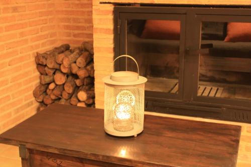 a lantern sitting on a table in front of a fireplace at Casa el Escalerón in Uña