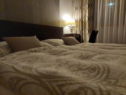 a bed in a bedroom with a white blanket at Villa Quality Wellness in Dozmat