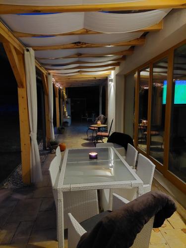 a table and chairs in a room with a ceiling at Villa Quality Wellness in Dozmat