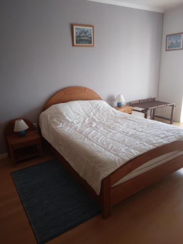 sypialnia z łóżkiem z drewnianym zagłówkiem w obiekcie Appartement à LOURINHA - 1er étage w mieście Lourinhã