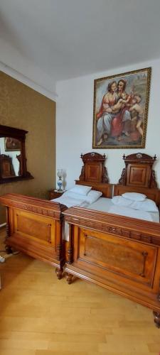 two beds in a room with a painting on the wall at Villa Luca in Mosonmagyaróvár