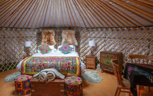 sypialnia z łóżkiem w jurcie w obiekcie HAYNE BARN ESTATE - 2 Luxury heated Yurts - private hot tub- private bathroom and kitchen w mieście Hythe
