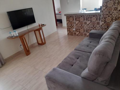 a living room with a couch and a flat screen tv at Apartamento Aconchegante SETOR OESTE in Goiânia