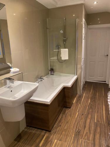 un bagno con vasca, lavandino e doccia di Balcony House Apartment in Kendal a Kendal