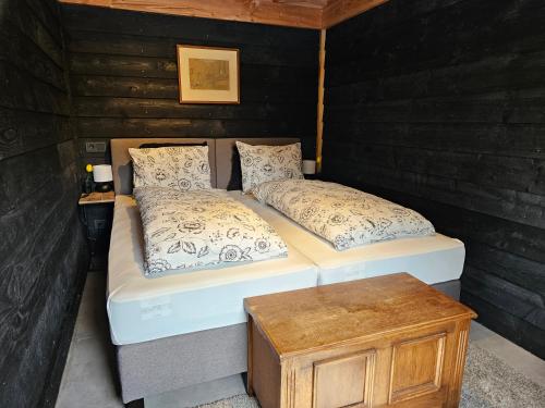 two twin beds in a room with a wooden wall at Ham Annex met privé jacuzzi in Almelo