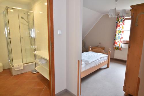 um pequeno quarto com uma cama e um chuveiro em Gościniec Nowa Wioska em Wałbrzych