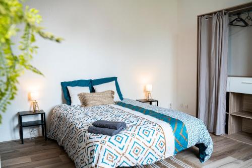 Schlafzimmer mit einem Bett mit einer blauen und weißen Bettdecke in der Unterkunft VILLA GABY - Rare 6 Personnes - Localisation Idéale in Pau