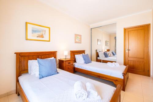 a bedroom with two beds and a mirror at Frente ao Mar - 2 quartos - wi-fi in Armação de Pêra