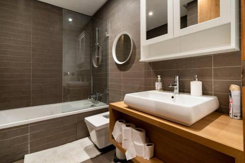 La salle de bains est pourvue d'un lavabo, de toilettes et d'une baignoire. dans l'établissement Luxury apartment Anfaplace, close to the beach, à Casablanca