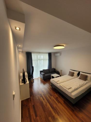 1 dormitorio grande con 1 cama y 1 sofá en Apartament Wierzbowa 6 z klimatyzacja (air-conditioning) en Poznan
