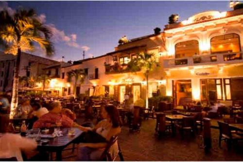 een groep mensen die 's nachts in een restaurant zitten bij Habitación cerca del Mar, Obelisco Macho y Zona Colonial in Santo Domingo