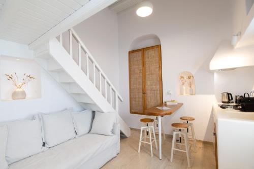 salon z białą kanapą i schodami w obiekcie MYKONOS HOUSE Aurora , Mykonos Town w mieście Mykonos