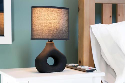 a lamp sitting on a nightstand next to a bed at Central Buckingham Apartment #1 with Free Parking, Pool Table, Fast Wifi and Smart TV with Netflix by Yoko Property in Buckingham