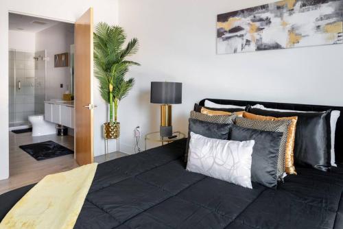 um quarto com uma grande cama preta com almofadas em Luxurious & Comfy Downtown Oasis ~ Views ~ Parking em Charlotte