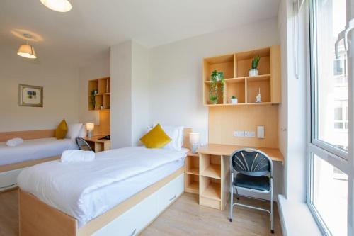 a room with a bed and a desk and a window at 106 - The Townhouse by Shortstays in Galway