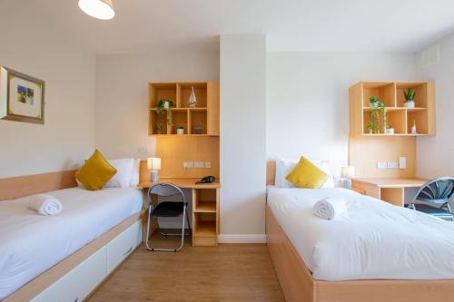 a room with two beds and a desk in it at 106 - The Townhouse by Shortstays in Galway