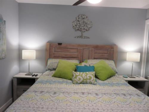 a bedroom with a bed with green and blue pillows at Our Happy Place in Destin