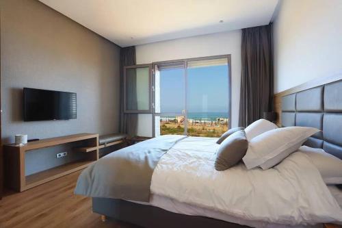a bedroom with a large bed with a large window at Luxury Apartment at Corniche , Seaview Close Beach in Casablanca