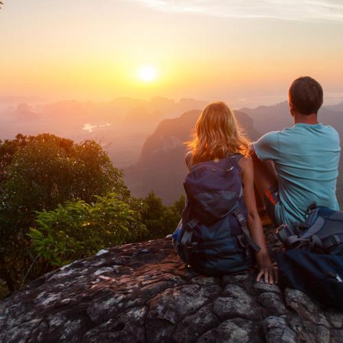 a couple sitting on top of a mountain watching the sunset at Hotel Termas Puyehue Wellness & Spa Resort in Puyehue