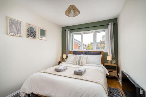 ein Schlafzimmer mit einem großen Bett und einem Fenster in der Unterkunft Homely and Stylish Bermondsey Apartment with Parking in London