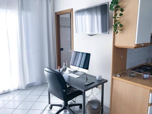 a desk with a computer on it in a kitchen at Vinciguerra Central House Tuscany in Altopascio