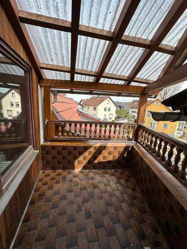 a balcony with a wooden roof with a window at Pension Asel in Wörth am Rhein