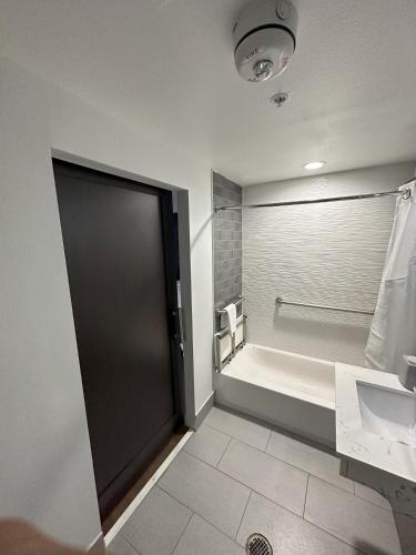 a bathroom with a tub and a toilet and a door at Holiday Inn Express - Dallas Downtown by IHG in Dallas