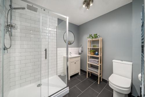 a bathroom with a shower and a toilet and a sink at Homely and Stylish Bermondsey Apartment with Parking in London