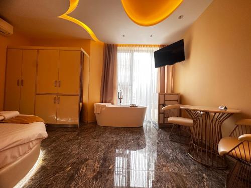 een badkamer met een bad, een bed en een televisie bij Hidden Bank: Pearls in Plovdiv