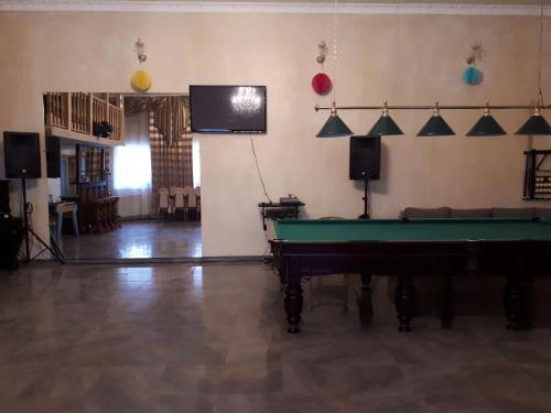 ein Wohnzimmer mit einem Billardtisch und einem Flachbild-TV in der Unterkunft Апартаменти 100 кв.м на Шота Руставелі in Odessa