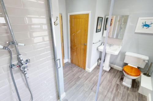 a bathroom with a shower and a toilet and a sink at CROYDE BRIAR HOUSE 4 Bedrooms in Croyde
