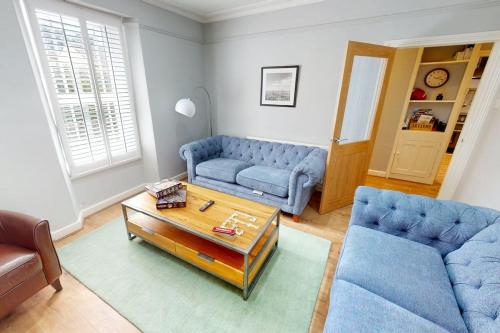 a living room with two blue couches and a coffee table at CROYDE BRIAR HOUSE 4 Bedrooms in Croyde