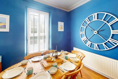 a dining room with a large clock on the wall at CROYDE BRIAR HOUSE 4 Bedrooms in Croyde