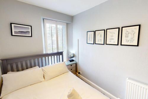 a bedroom with a bed and four pictures on the wall at CROYDE BRIAR HOUSE 4 Bedrooms in Croyde