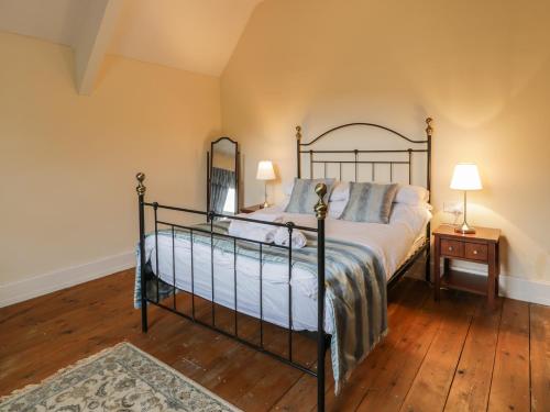 een slaapkamer met een bed en een houten vloer bij The Mill House in Carrog