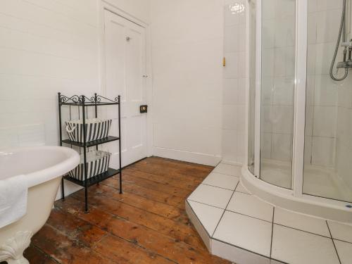 a white bathroom with a shower and a sink at The Mill House in Carrog