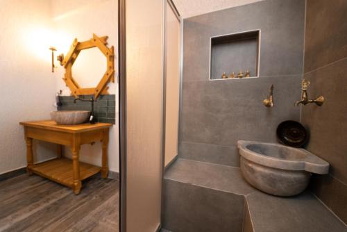 a bathroom with a tub and a sink and a mirror at Watermill Villa & Hotel Faralya in Fethiye