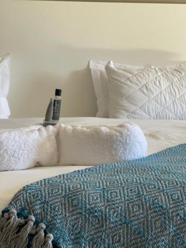 a white bed with pillows and a blanket on it at LEGENDS EXECUTIVE LODGE in Choma