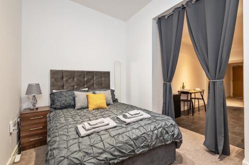 Luxe Apartment Central Bradford في برادفورد: غرفة نوم عليها سرير وفوط
