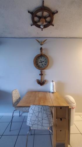 a clock on a wall next to a table and chairs at NAÜTIK, Ocean Front! Great view in Fajardo