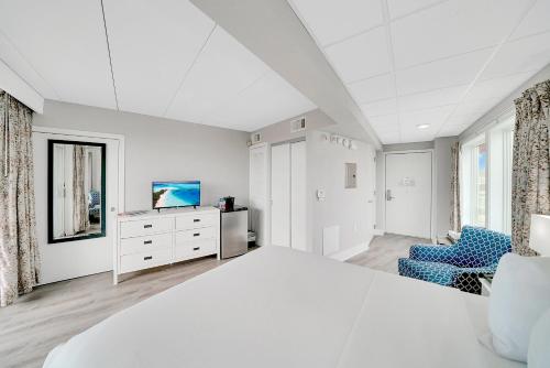 a white bedroom with a bed and a tv at Montreal Beach Resort in Cape May
