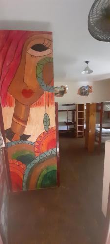 une chambre avec une peinture d'une femme sur le mur dans l'établissement Hostel Estacion Mendoza, à Mendoza