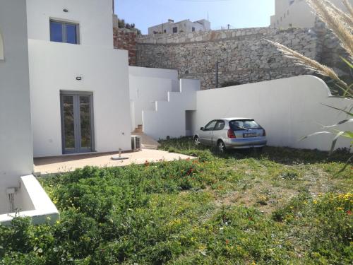 a car parked in front of a white building at GRΕΛΙΑ ΗΟΜΕ in Naxos Chora