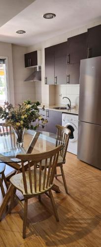 a kitchen with a table and chairs and a refrigerator at Apto Valentina Salou in Salou