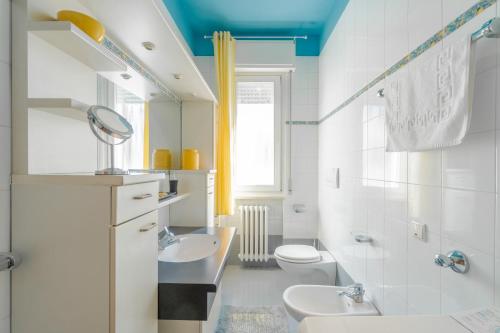 a white bathroom with a sink and a toilet at Viale della Repubblica free parking e Wifi 1 minute to Garda Lake in Peschiera del Garda