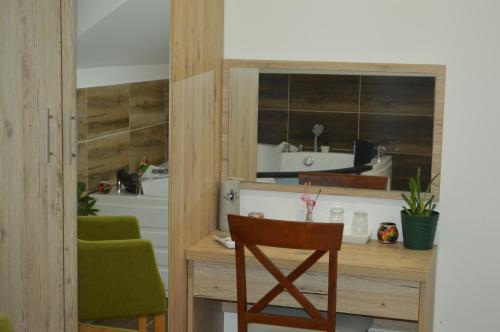Il comprend une cuisine avec un bureau et une chaise verte. dans l'établissement Vila Voždov Konak, à Rača