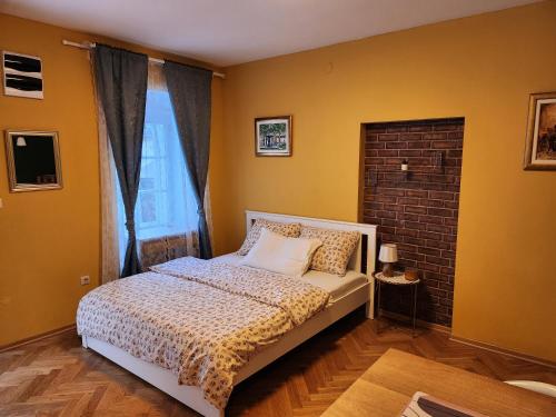 1 dormitorio con cama y pared de ladrillo en Center Gradec Apartment en Zagreb