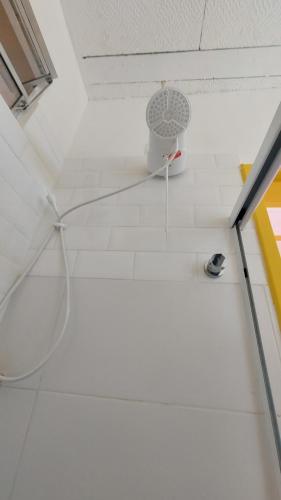 a white bathroom with a shower with a hoop at Hotel Casa Bonita in Campo Grande