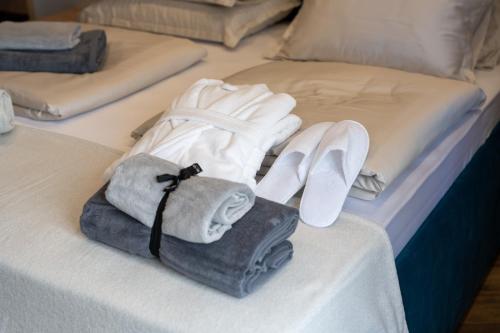 a bed with towels and shoes on it at West Coast Deluxe Rooms - Vacation Rental in Split